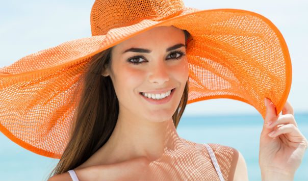 woman wearing a large orange sunhat