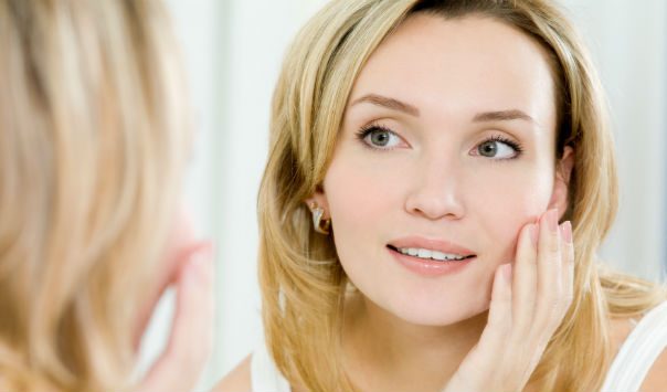 woman with blonde hair looking in a mirror