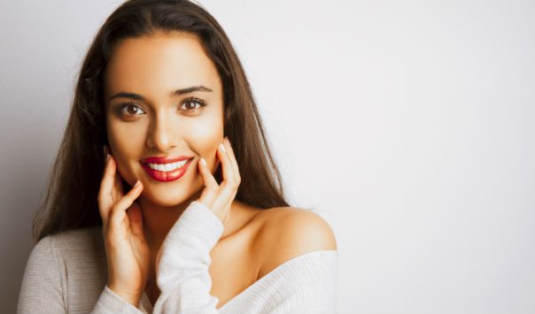 woman wearing a long sleeve top touching her face