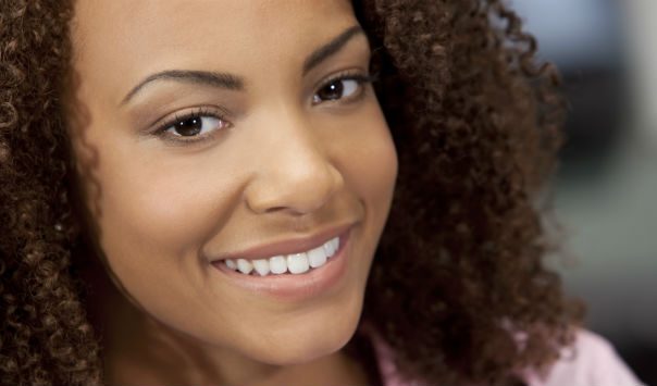 woman with dark curly hair smiling